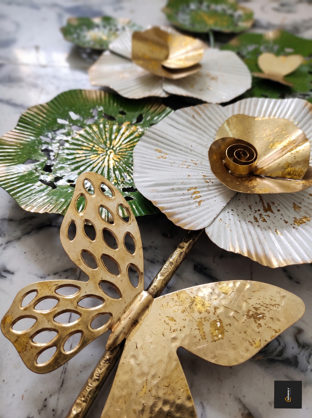Decorative gold and silver leaf-shaped objects on a marble surface