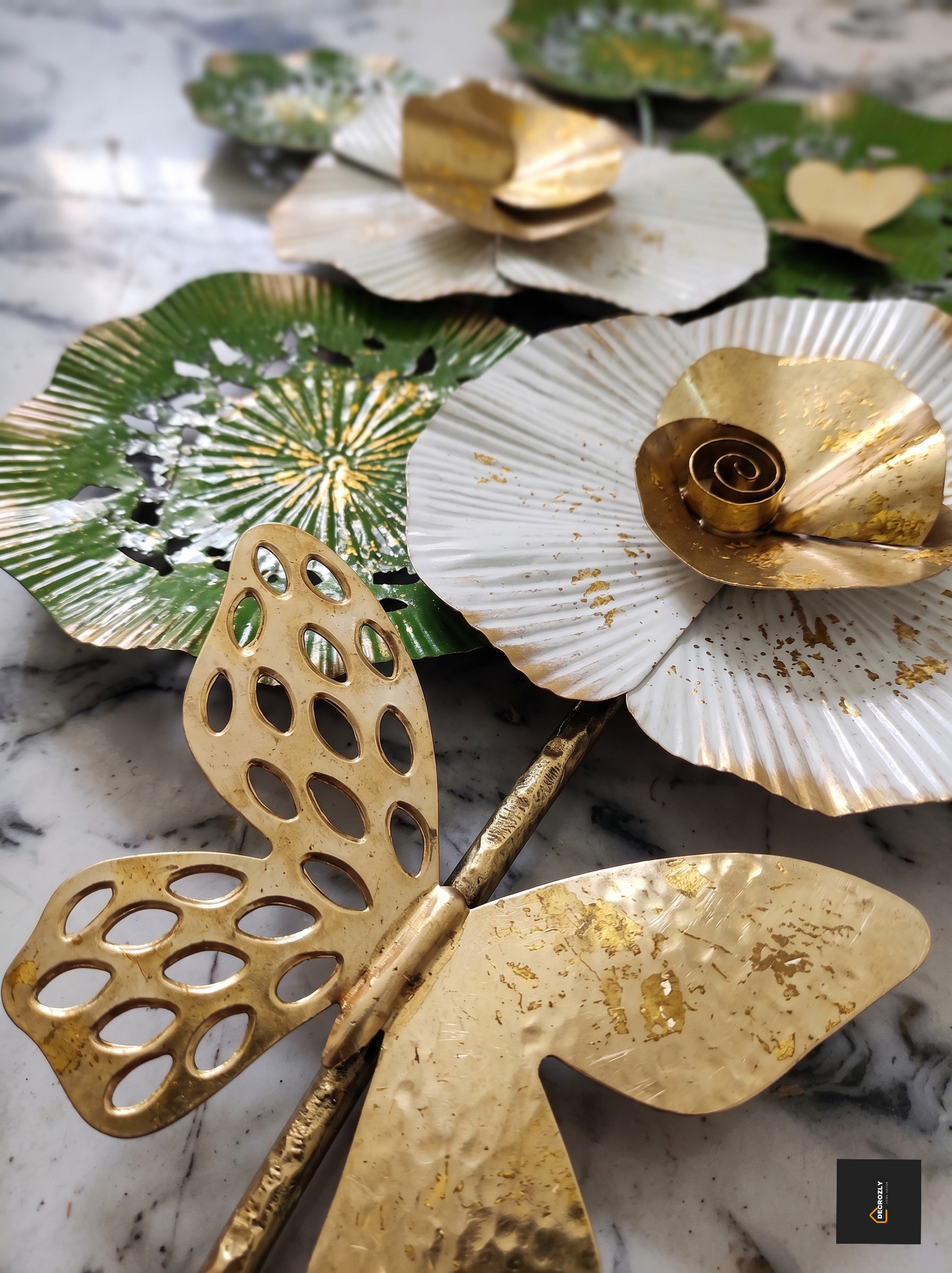 Decorative gold and silver leaf-shaped objects on a marble surface