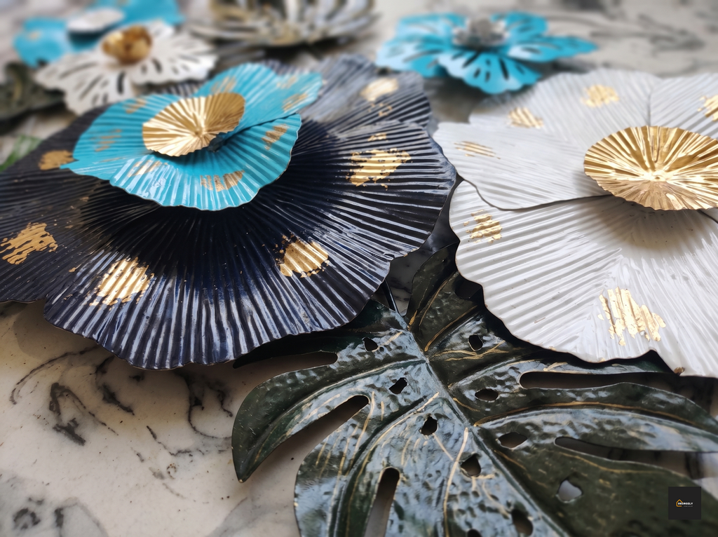 Decorative Metal wall art in blue, black, and white with gold accents on a marble surface.