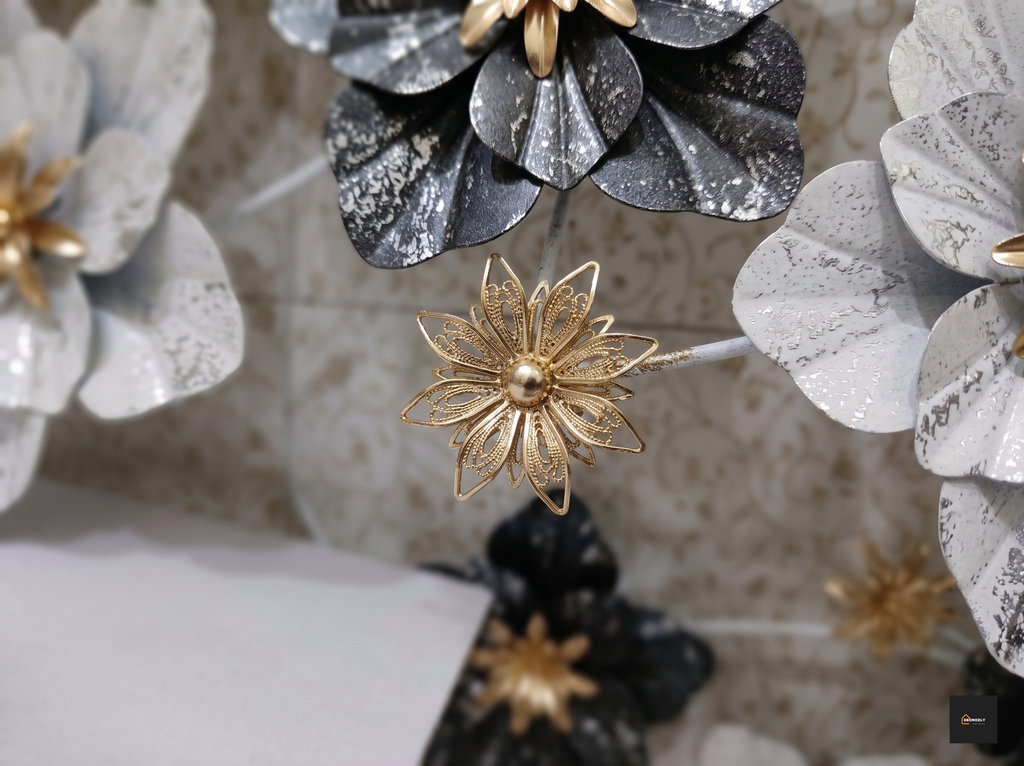 Gold flower-shaped hair clip on a decorative headband with gray and black flowers.
