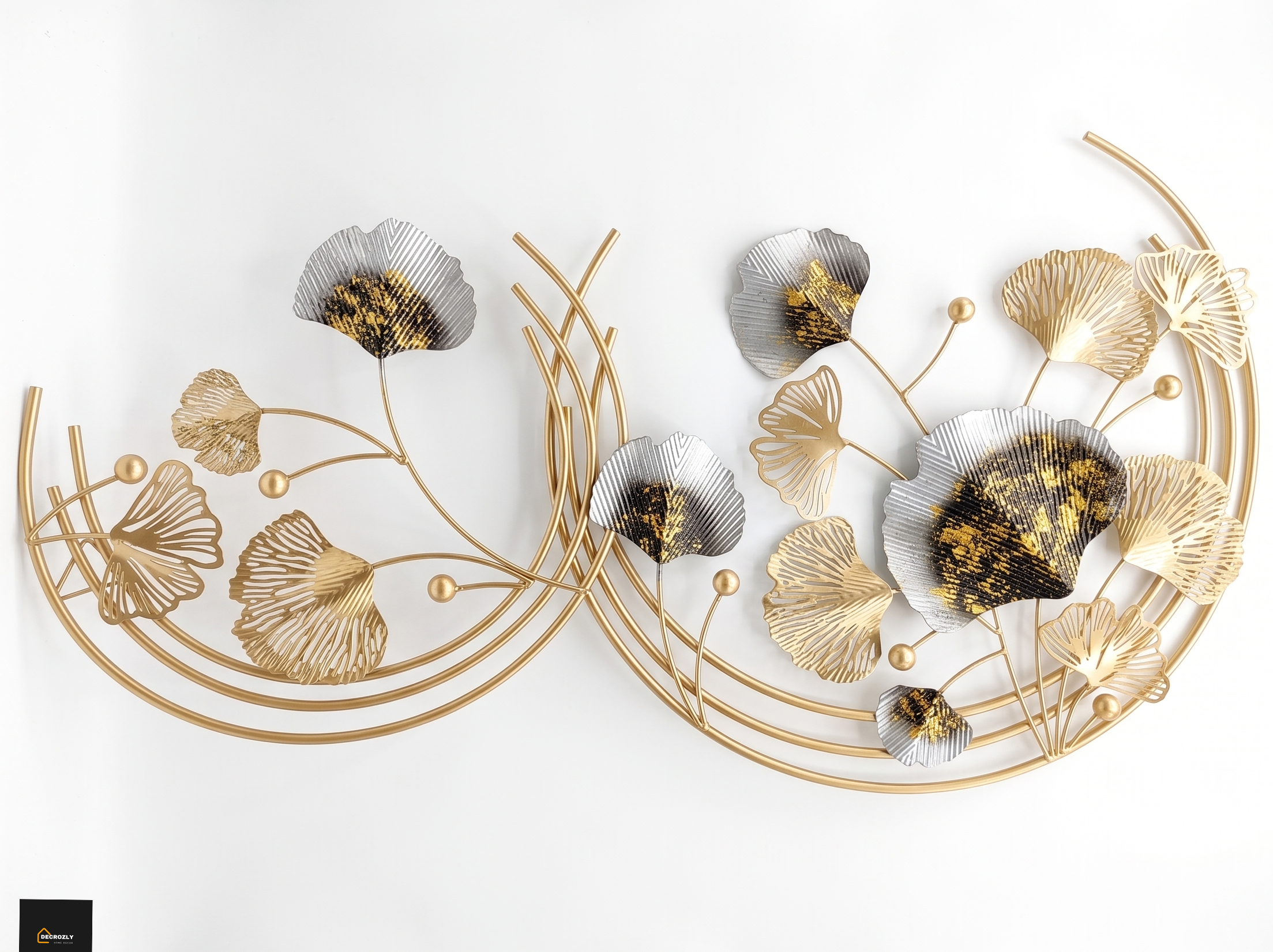 Decorative wall art with gold and silver floral designs on a white background