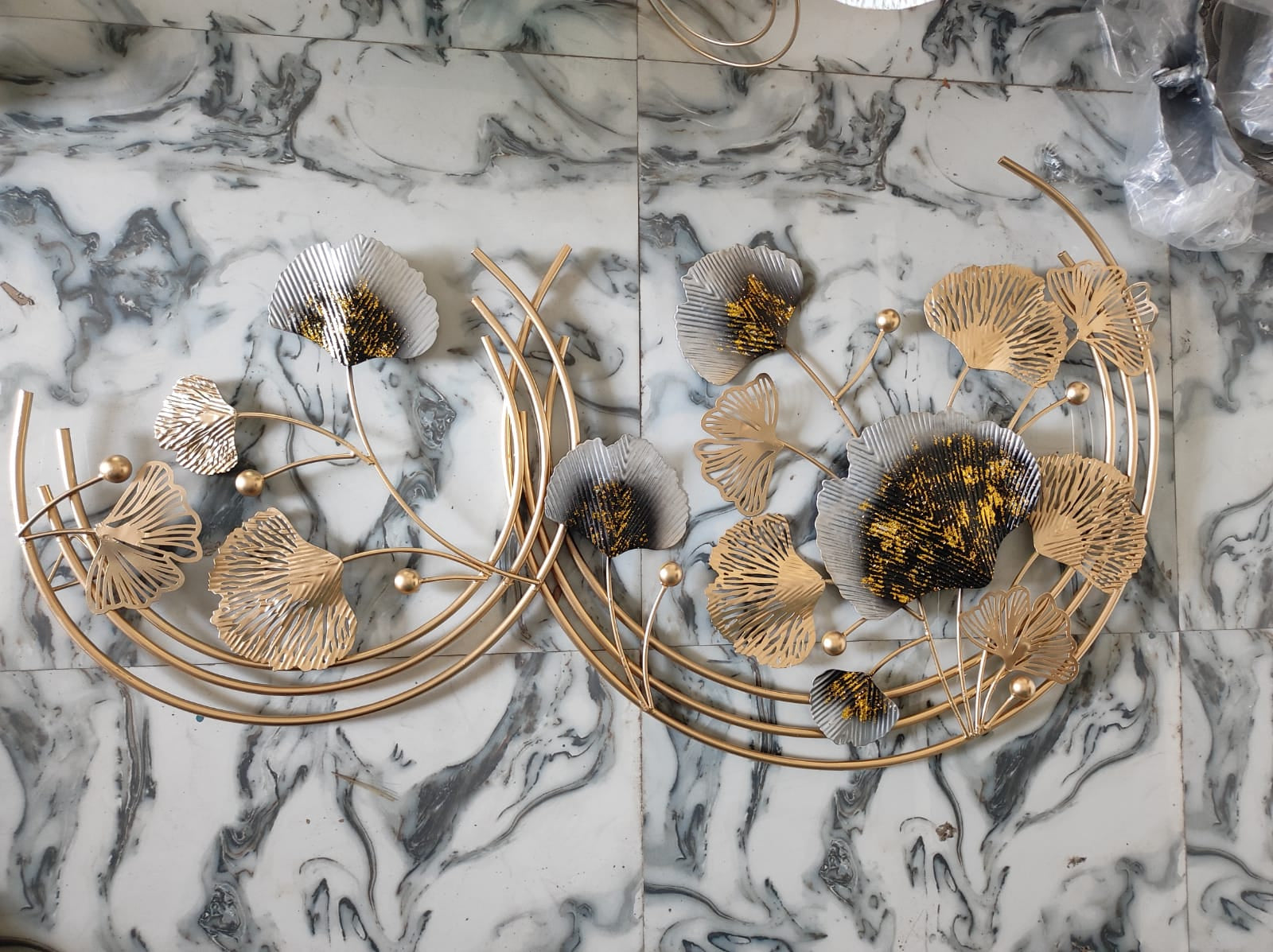 Decorative wall art with gold leaf design on a marble surface