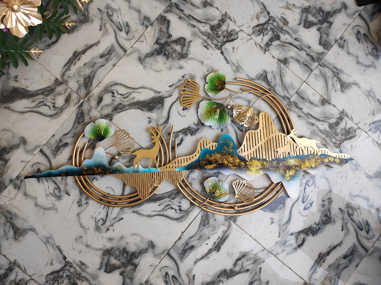 Decorative wall art with gold and blue elements on a marble surface